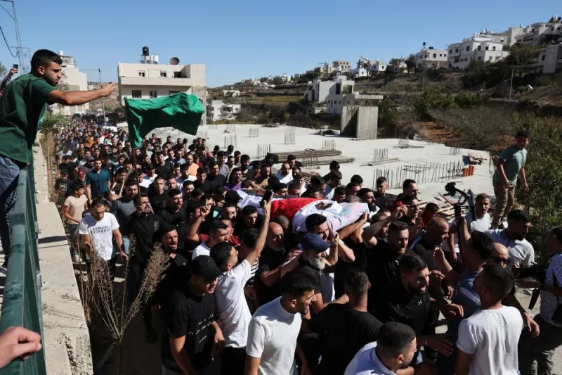 Mourners carry the body of 21-years-old Palestinian Mahmoud Atrash who was killed in an Israeli raid, during his funeral in Halhul near Hebron in the Israeli-occupied West Bank, Monday. REUTERS