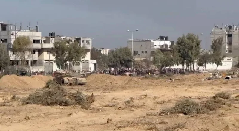 A still image taken from a video shows what the Israeli army says are Palestinians holding white flags as they walk from north Gaza to the south near an Israeli tank in a location given as Gaza, obtained by Reuters on Tuesday. Israeli Defense Forces/Handout via REUTERS