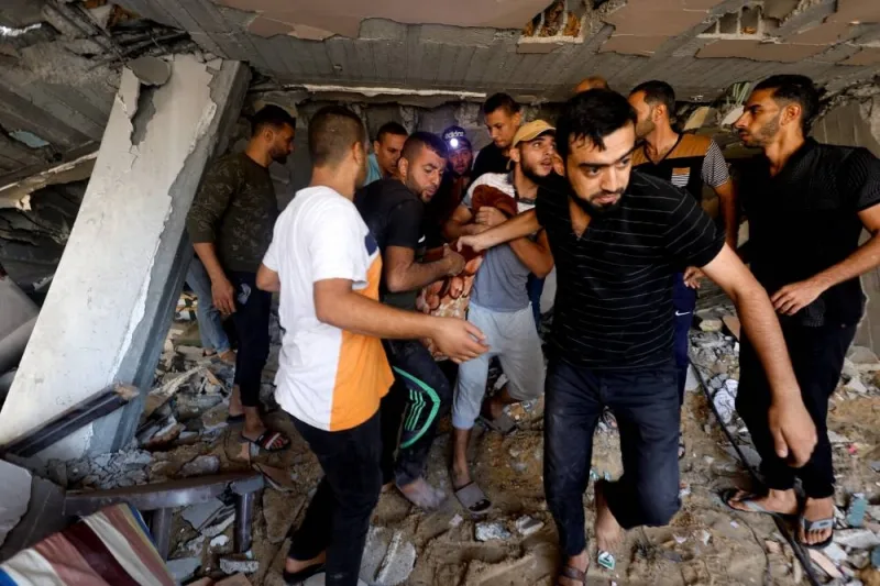 Palestinians carry a casualty at the site of Israeli strikes on a residential building in Khan Younis in the southern Gaza Strip, on Tuesday. REUTERS