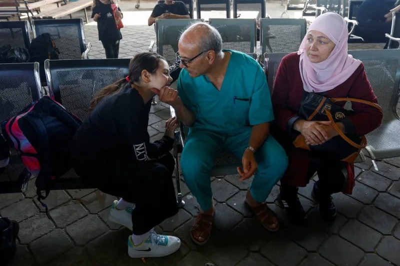 Palestinian doctor Mohammad Abu Namoos, who chose to stay in Gaza to treat patients, says goodbye to his family before they leave the strip, amid the ongoing conflict with Israel, at Rafah border crossing, in Rafah in the southern Gaza Strip, Tuesday. REUTERS