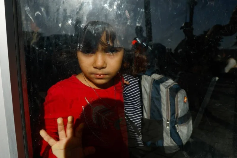A girl looks on from behind a glass as Palestinians with foreign passports wait for permission to leave Gaza, at the Rafah border crossing with Egypt, in Rafah in the southern Gaza Strip, Tuesday. REUTERS