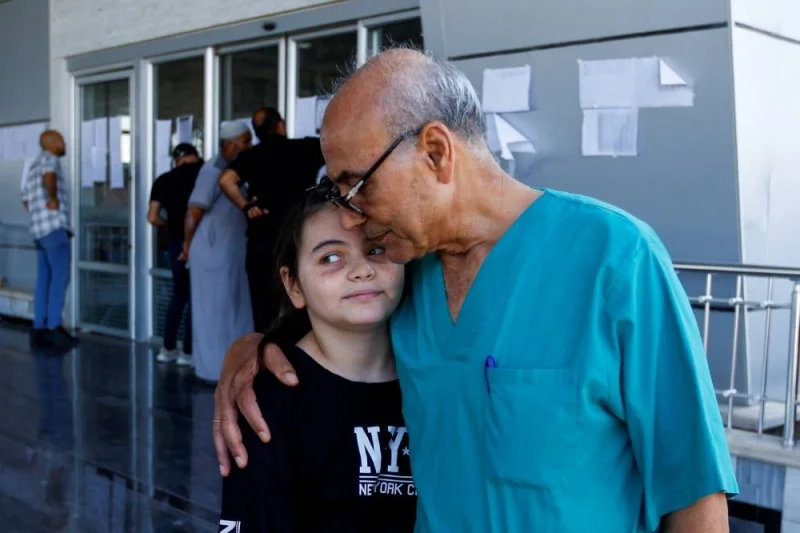 Palestinian doctor Mohammad Abu Namoos, who chose to stay in Gaza to treat patients, says goodbye to his daughter Dina before she leaves the strip, in Rafah in the southern Gaza Strip, Tuesday. REUTERS