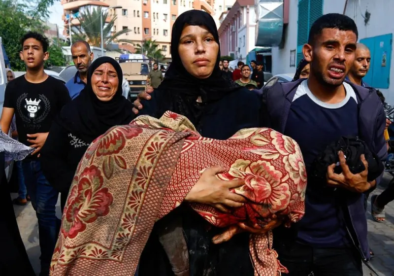 A woman holds a body of a Palestinian killed in Israeli strikes in Khan Younis in the southern Gaza Strip, Wednesday. REUTERS
