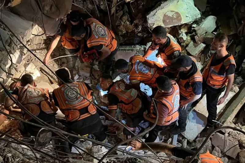 Palestinian rescuers search for casualties under the rubble of a house hit by an Israeli strike, in Gaza City, Wednesday. REUTERS