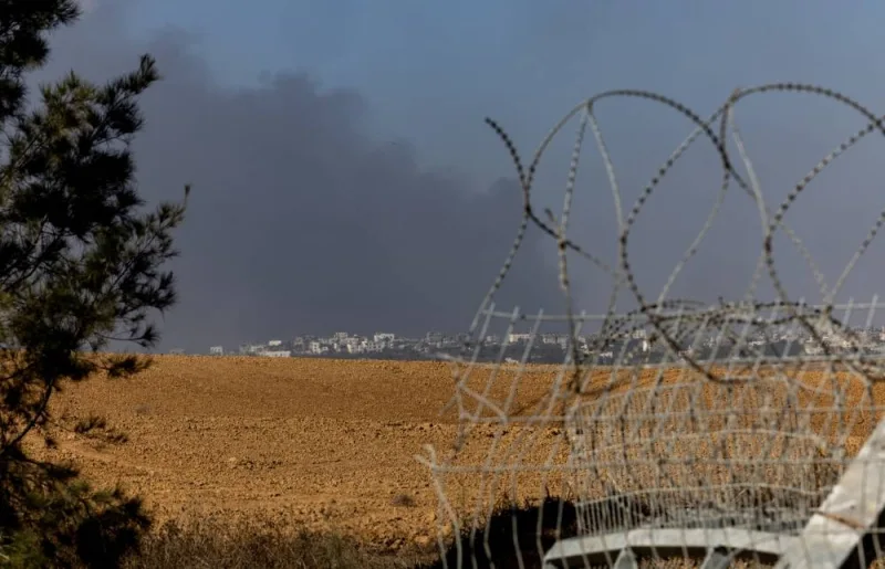 Smoke rises from Gaza as seen from the broken fence where Hamas gunmen entered Israel during the October 7th attack, in Kfar Aza, Israel Wednesday. REUTERS