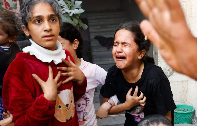 Palestinian children react after an Israeli strike on a house in Khan Younis in the southern Gaza Strip, on Saturday. REUTERS