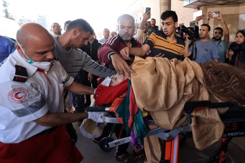 An injured woman is transported to an ambulance following an Israeli strike in Khan Yunis in the southern Gaza Strip, on Saturday. AFP