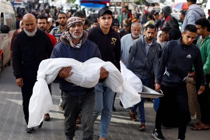 A man carries the body of a Palestinian child killed in Israeli strikes in Khan Younis in the southern Gaza Strip, on Sunday. REUTERS