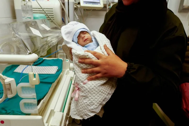 A Palestinian mother holds her newborn Anas Sbeta, who was placed in an incubator after being evacuated from Al Shifa Hospital in Gaza, as he is discharged from a hospital in Rafah, southern Gaza Strip, on Tuesday. REUTERS