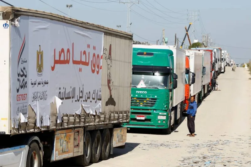 A man stands near aid trucks that arrived at the Rafah border crossing with Egypt during a temporary truce between Hamas and Israel, in Rafah in the southern Gaza Strip Friday.
