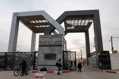 A man stands in a gate while people gather at the Rafah border, as Hamas is expected to release hostages, as part of a hostages-prisoners swap deal between Hamas and Israel, seen from southern Gaza Strip, Saturday. REUTERS