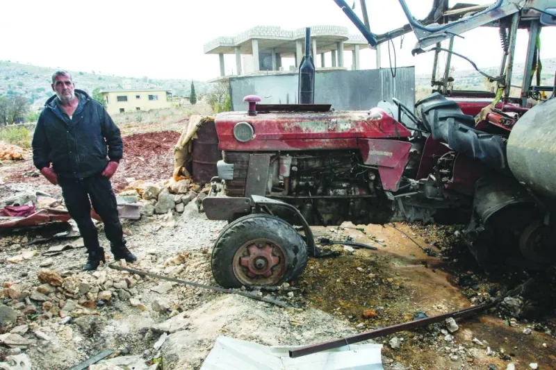 
Lebanese farmer and minibus driver Abdallah Abdallah stands in front of his tractor destroyed by an Israeli strike as he inspects his damaged home in Aitaroun, southern Lebanon, yesterday. 