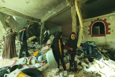 
Palestinian girls pick up salvageable items from their damaged apartment in the Khezaa district on the 
outskirts of the southern Gaza Strip city of Khan Yunis, during the truce, yesterday. 