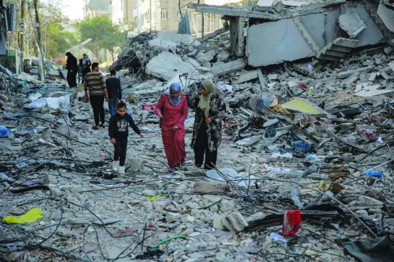 
Palestinians walk amidst the rubble of destroyed buildings in Gaza City, yesterday, on the third day of a truce between Israel and Hamas. 