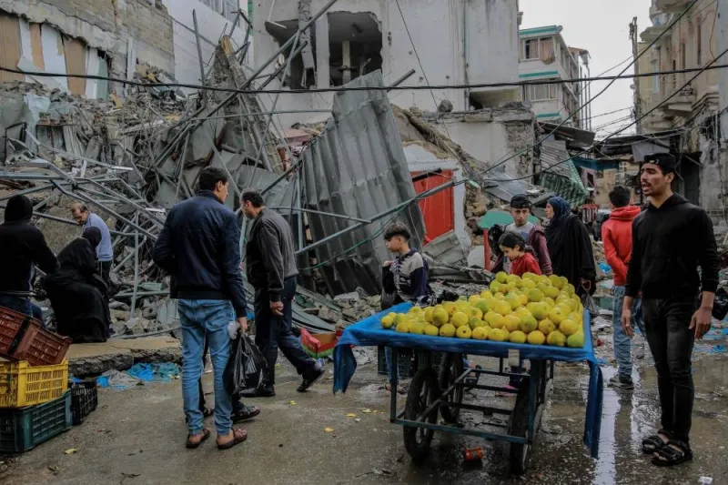 Palestinians sells vegetables amid debris of buildings hit in Israeli strikes, near Al-Zawiya market in Gaza City on Monday, on the fourth day of a truce in fighting between Israel and Hamas. AFP