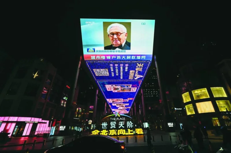 An outdoor screen in Beijing shows a news programme following the death of former US secretary of state Henry Kissinger.