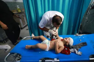 A Palestinian doctor gives medical care to a toddler injured in an Israeli strike on Rafah in the southern Gaza Strip, at the al-Najjar hospital on Friday, after battles resumed between Israel and Hamas movement. AFP