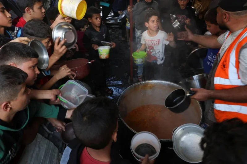 Palestinians gather to get their share of charity food offered by volunteers, amid food shortages, in Rafah, in the southern Gaza Strip, on Saturday. REUTERS