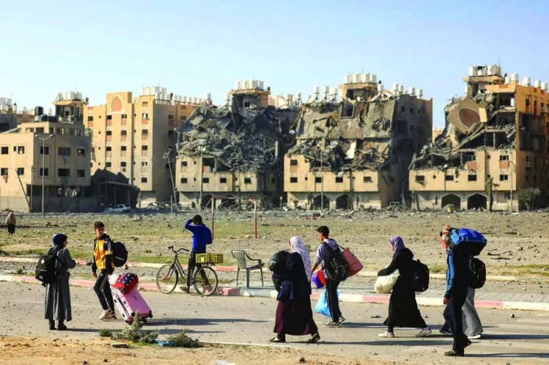 
Residents of the Hamad Town residential complex in Khan Yunis in the southern Gaza Strip, carry some of their belongings as they flee their homes after an Israeli strike, yesterday. 