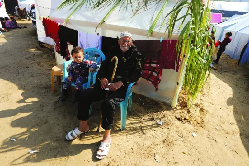 
Displaced Palestinian man Abu Wael Nasrallah sits next to his grandchild near their tent where they take shelter, as the conflict between Israel and Hamas continues, at Nasser hospital in Khan Yunis, in the southern Gaza Strip, yesterday. 