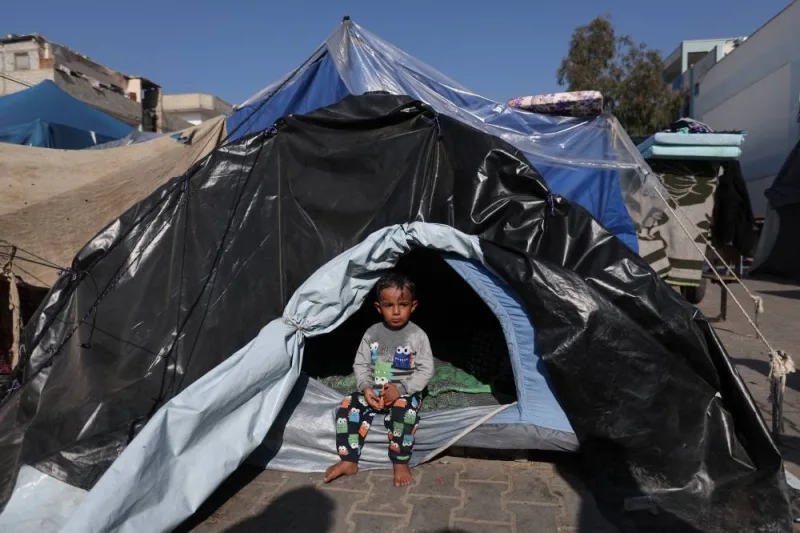 A child sits in a tent as Palestinians, who fled their houses amid Israeli strikes, shelter at a United Nations-run school, in Khan Younis, in the southern Gaza Strip, on Monday. REUTERS