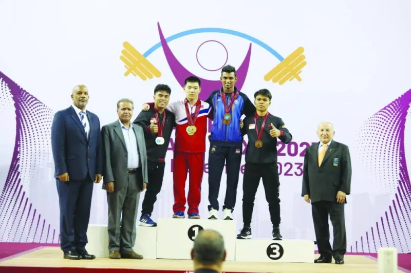 
The podium finishers in the men’s 55kg class pose with the officials.  
