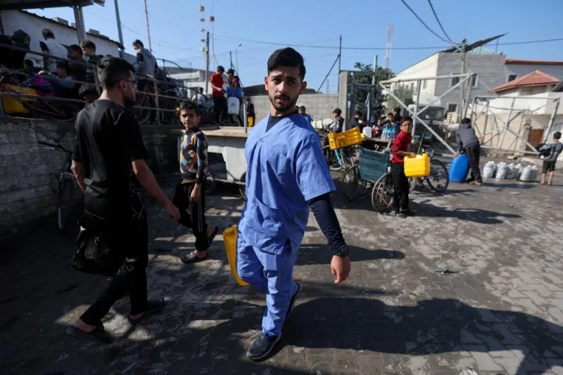 Mahmoud Hisham Abu Lamdi, a 23-year-old nurse displaced from Al-Shati refugee camp in the north of Gaza, walks with a water can, amid the ongoing conflict between Israel and the Palestinian Islamist group Hamas, in the southern city of Khan Younis, on Tuesday. REUTERS