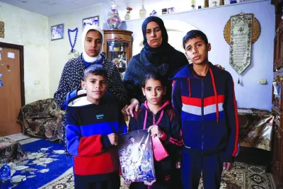 
Ikhlas, the widow of Bilal Saleh, poses with her children as they hold a picture of their late father at the village of As-Sawiyah, south of Nablus in the occupied West Bank. 