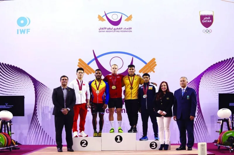 
Podium finishers pose with the officials during the Qatar Cup IWF Grand Prix II held at the Aspire Zone yesterday. 
