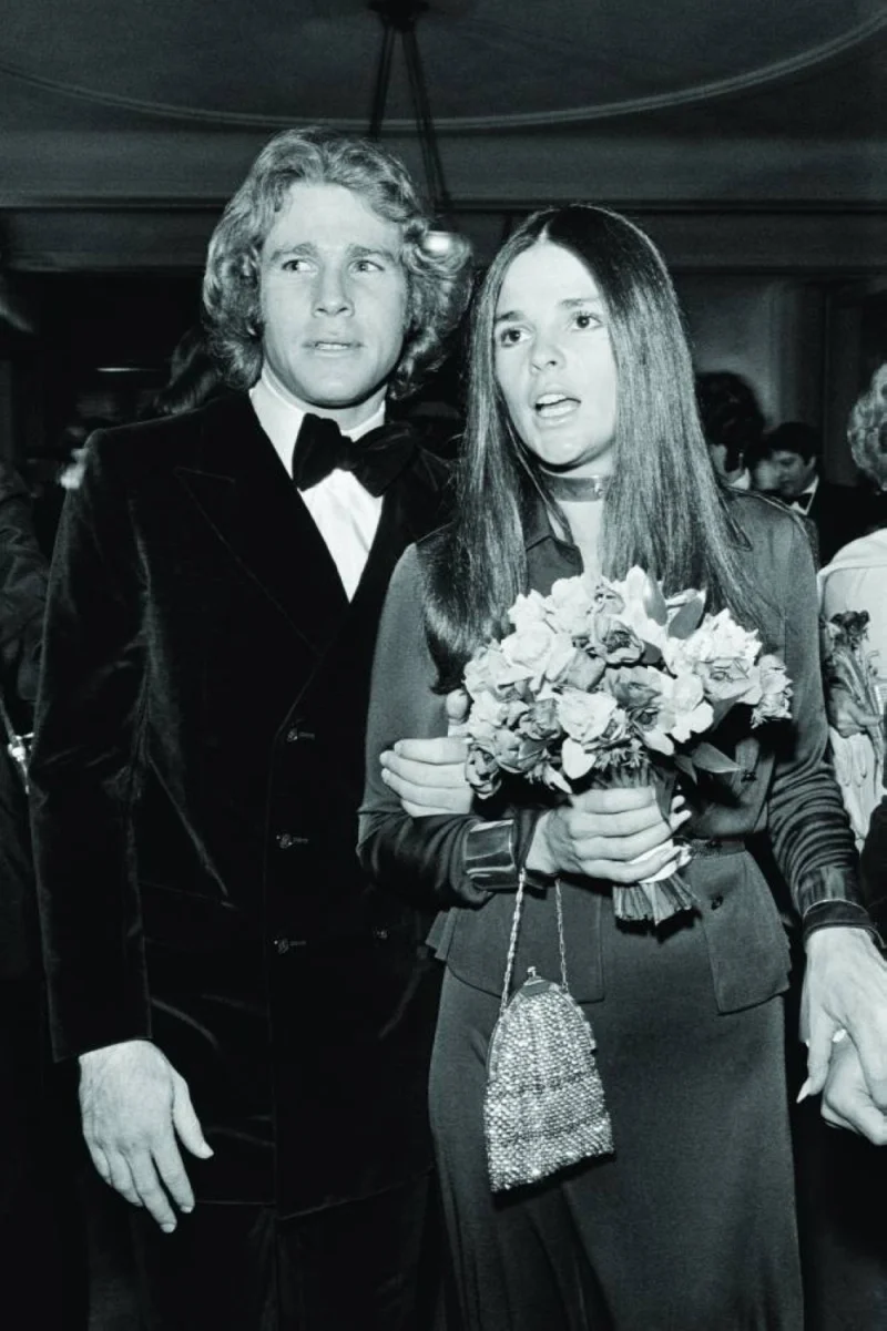 US actor Ryan O'Neal and US actress Ali MacGraw arrive to attend the premiere of the film Love Story at the Theatre des Champs Elysees in Paris on March 19, 1971. (AFP)