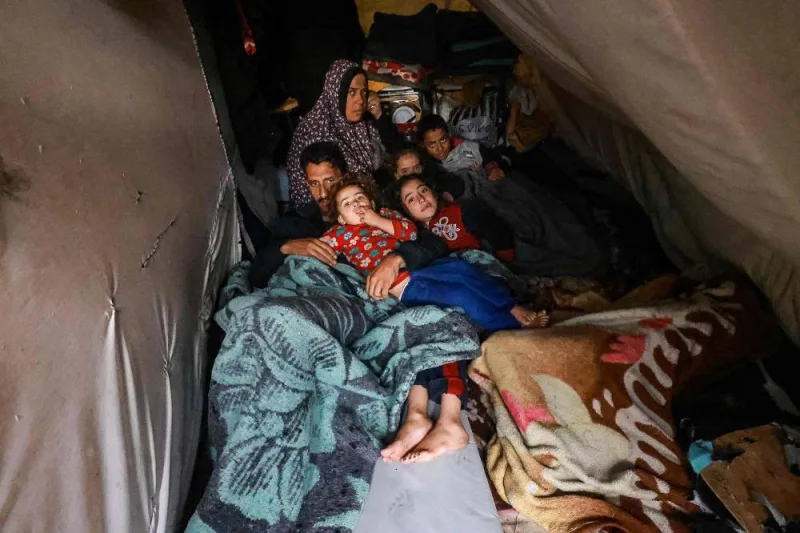 Palestinians rest in their makeshift tent at a camp set up on a schoolyard in Rafah in the southern Gaza Strip where most civilians have taken refuge, on Wednesday. AFP 