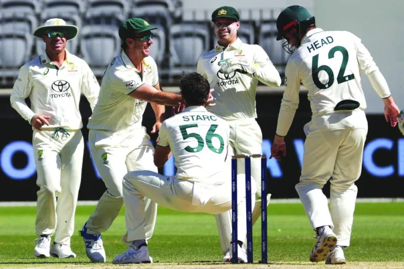 Australia’s Mitchell Starc (centre) celebrates with teammates after taking the wicket of Pakistan’s Sarfaraz Ahmed on day four of the first Test in Perth yesterday. (AFP)