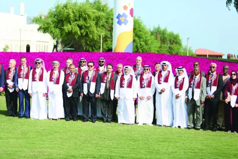 Officials with guests pose near the &#039;flowery flag&#039; at the Doha Expo 2023 venue