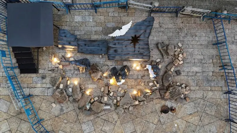 A Christmas installation of a grotto with figures standing amid rubble surrounded by a razor wire is displayed outside the Church of the Nativity, in support of Gaza, on Manger Square in Bethlehem on Christmas Eve, in the Israeli-occupied West Bank, Sunday. REUTERS