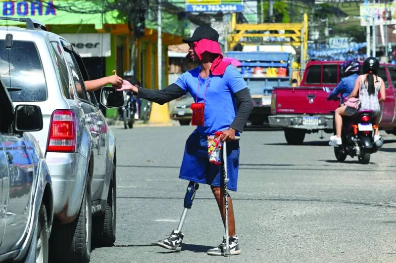 
Venezuelan migrant Marcel Maldonado offers candies to drivers to get some money for his journey to the Honduras-Guatemala border, in the town of Danli, El Paraiso department, Honduras.  