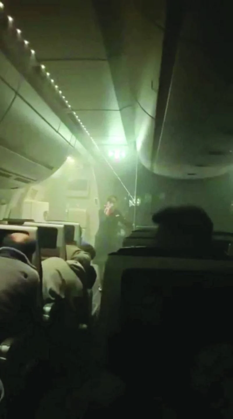 
People sit amid smoke inside the Japan Airlines’ A350 airplane in this screen grab obtained from social media video. 