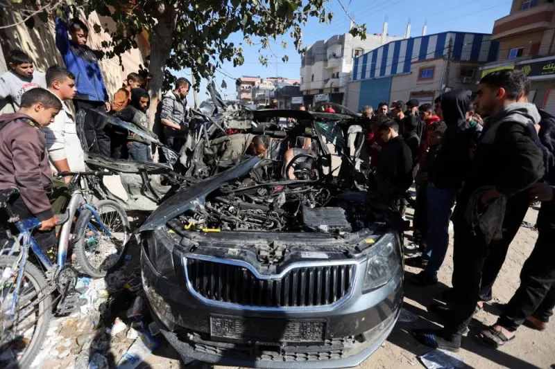 Palestinians inspect the remains of a car where Palestinian journalist Hamza Al-Dahdouh was killed along with another journalist in an Israeli strike, in Rafah in the southern Gaza Strip, on Sunday. REUTERS