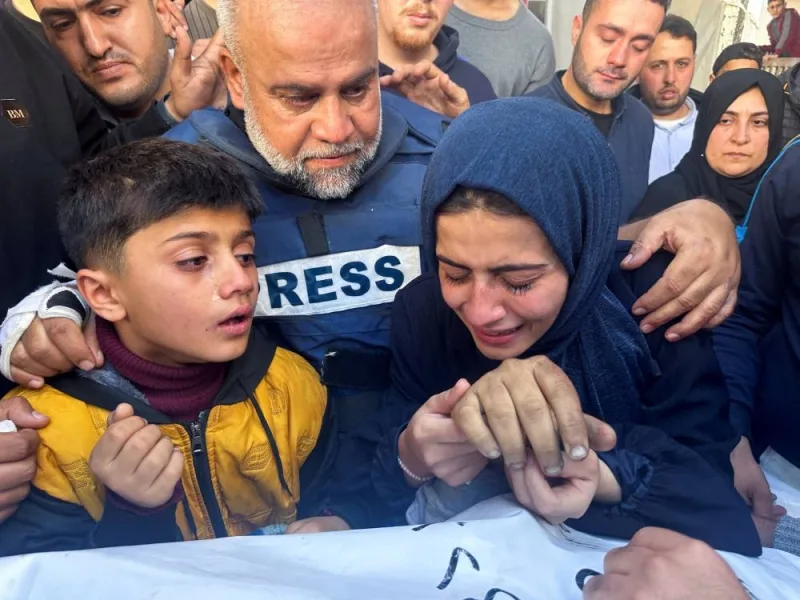 Al Jazeera journalist Wael Al-Dahdouh hugs his daughter and son as they attend the funeral of his son, Palestinian journalist Hamza Al-Dahdouh, after Hamza was killed in an Israeli strike, in Rafah in the southern Gaza Strip, on Sunday. REUTERS