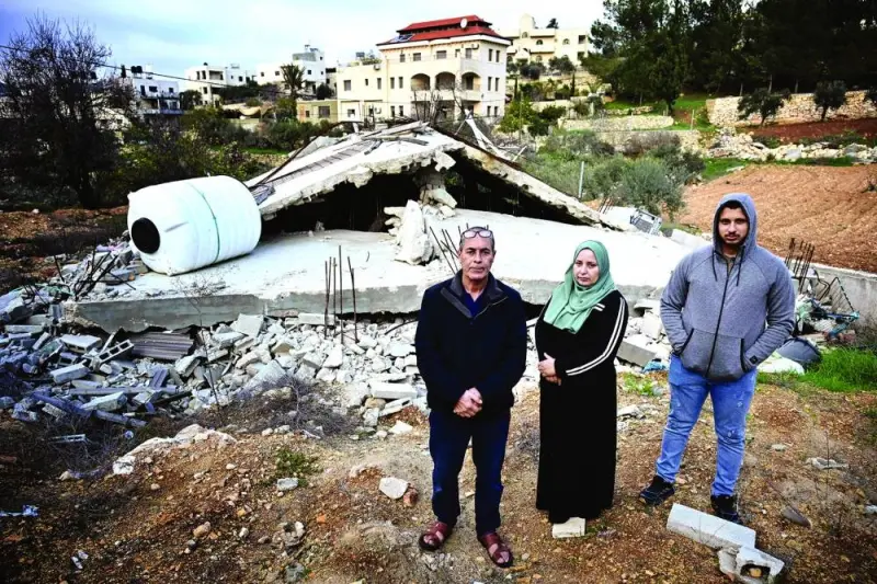 Palestinian family (from left) Waji, Ghadeer and Luai al-Atrash pose in front of their bulldozed home in 
Al-Walaja, a Palestinian village in annexed East Jerusalem.