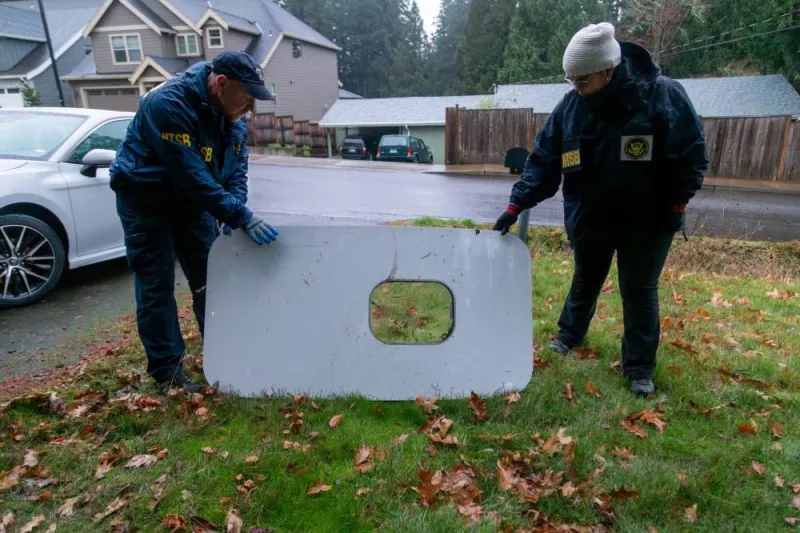 National Transportation Safety Board (NTSB) investigators examine the fuselage plug area of Alaska Airlines Flight 1282 Boeing 737-9 MAX, which was jettisoned and forced the aircraft to make an emergency landing, at a property where it was recovered in Portland, Oregon, US, Monday. NTSB/Handout via REUTERS.  
THIS IMAGE HAS BEEN SUPPLIED BY A THIRD PARTY