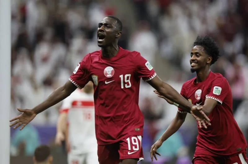 Qatar&#039;s Almoez Ali celebrates scoring their second goal with Yusuf Abdurisag. REUTERS