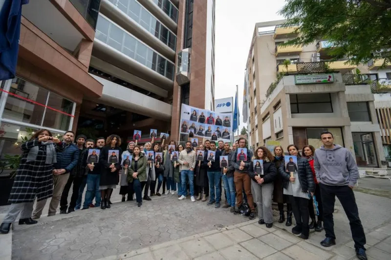 Agence France-Presse employees hold portraits of their colleagues outside its Middle East and North Africa (MENA) headquarters in Nicosia on Wednesday, in solidarity with AFP journalists working in Gaza. AFP