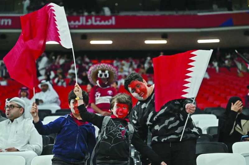 Fans hold Qatar’s flag during the AFC Asian Cup Group A match against Tajikistan on Wednesday. (AFP)