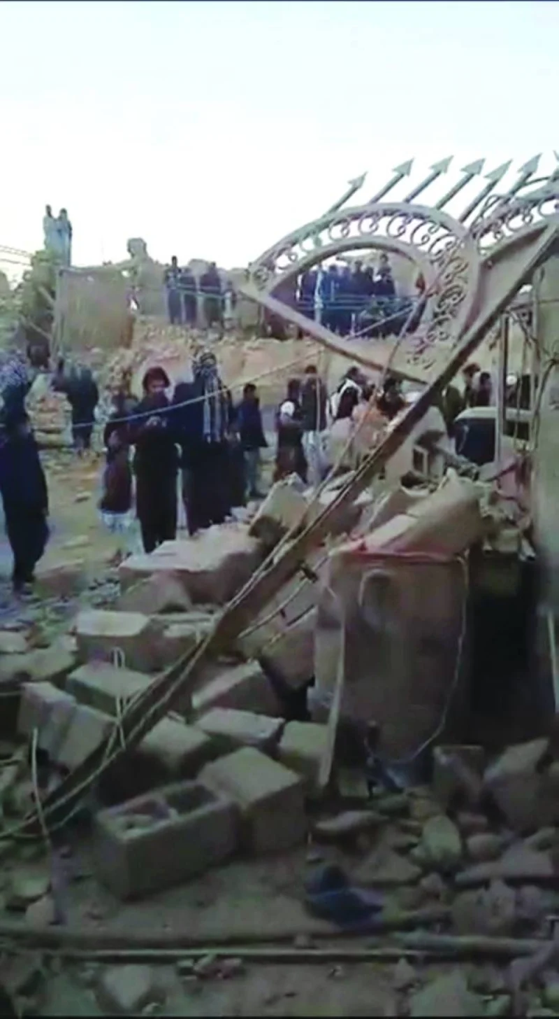 People gather near rubble in the aftermath of Pakistan’s military strike on an Iranian village near Saravan, in Iran’s Sistan-Baluchestan province, in this screen grab from social media video.