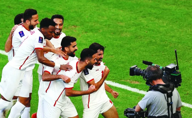 Jordan’s Yazan al-Naimat celebrates with teammates after scoring a goal during their AFC Asian Cup Group E clash against South Korea at Al Thumama Stadium in Doha on Saturday. (Reuters)
