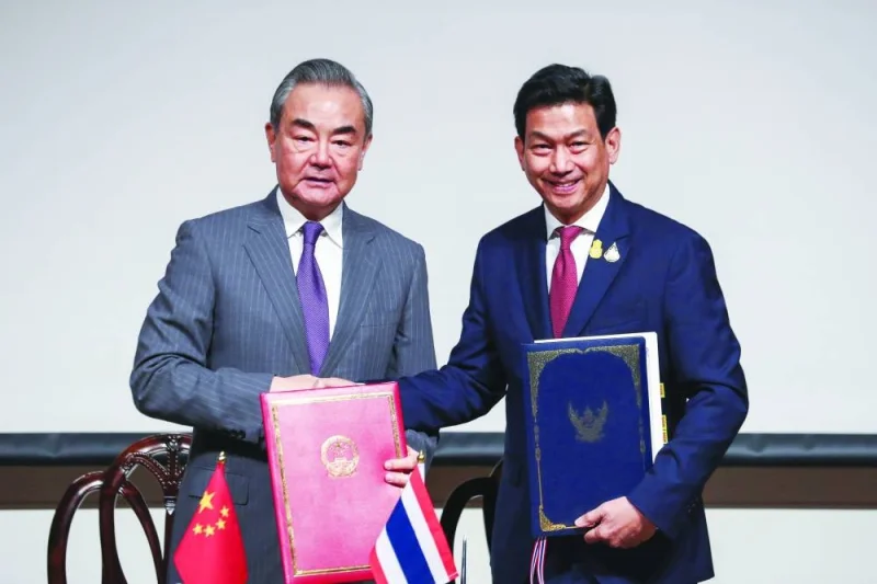 Chinese Foreign Minister Wang Yi and Thai Foreign Minister Parnpree Bahiddha-Nukara shake hands during a signing ceremony of the agreement on mutual visa exemption in Bangkok.