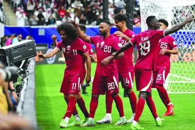 Qatar’s forward Akram Afif (left) celebrates with teammates after scoring a penalty during the AFC Asian Cup round of 16 match against Palestine at Al Bayt Stadium in Al Khor on Monday. (AFP)