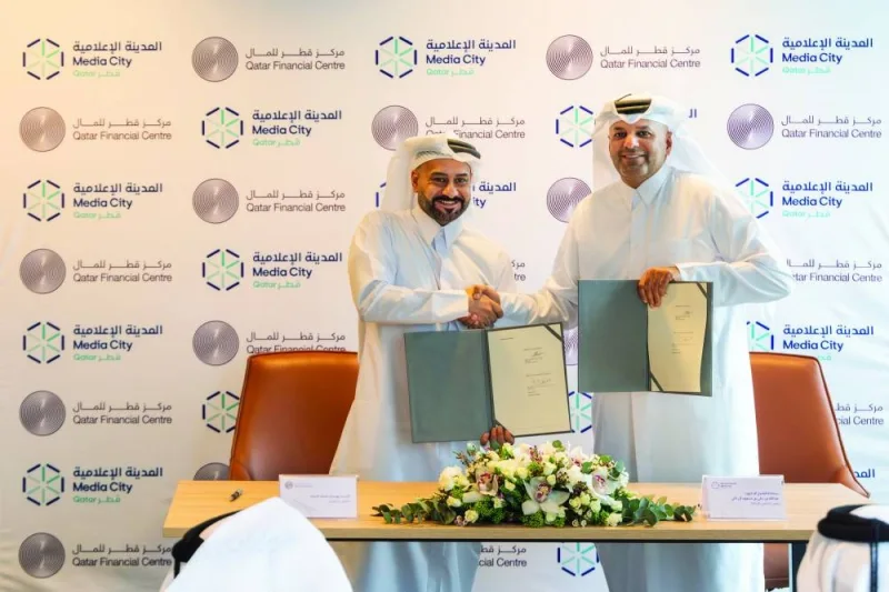 Sheikh Dr Abdulla bin Ali al-Thani, chairman, MCQ, and Yousuf Mohamed al-Jaida, chief executive officer, QFC, shaking hands after signing the pact.