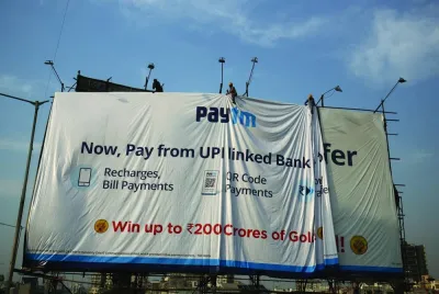
Workers adjust a hoarding of Paytm, a digital payments firm, in Ahmedabad (file). The Reserve Bank of India yesterday ordered Paytm Payments Bank Ltd, a unit of One97 Communications Ltd, to stop its popular mobile wallet business along with other activities, citing persistent non-compliance and supervisory concerns. 