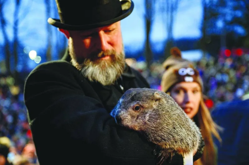 Groundhog handler AJ Dereume holds Punxsutawney Phil after he did not see his shadow, predicting an early Spring during the 138th annual Groundhog Day festivities in Punxsutawney, Pennsylvania.